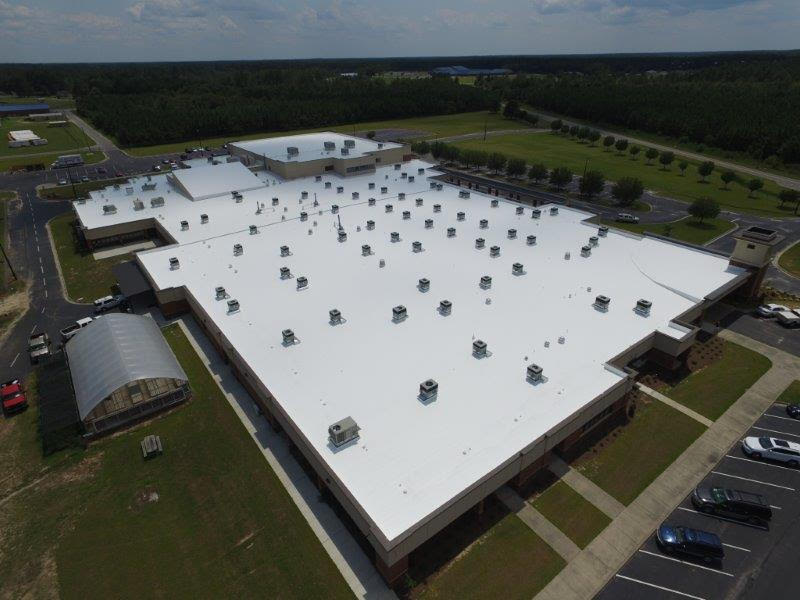 Commercial roof after ASTEC fluid-applied restoration — seamless reflective white coating